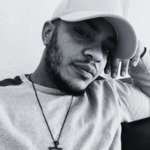 Deven poses for Trans Emergency Funds, his head resting on his arm.